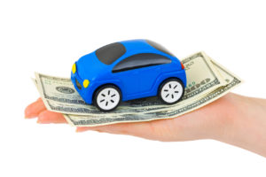 Hand with money and toy car isolated on white background